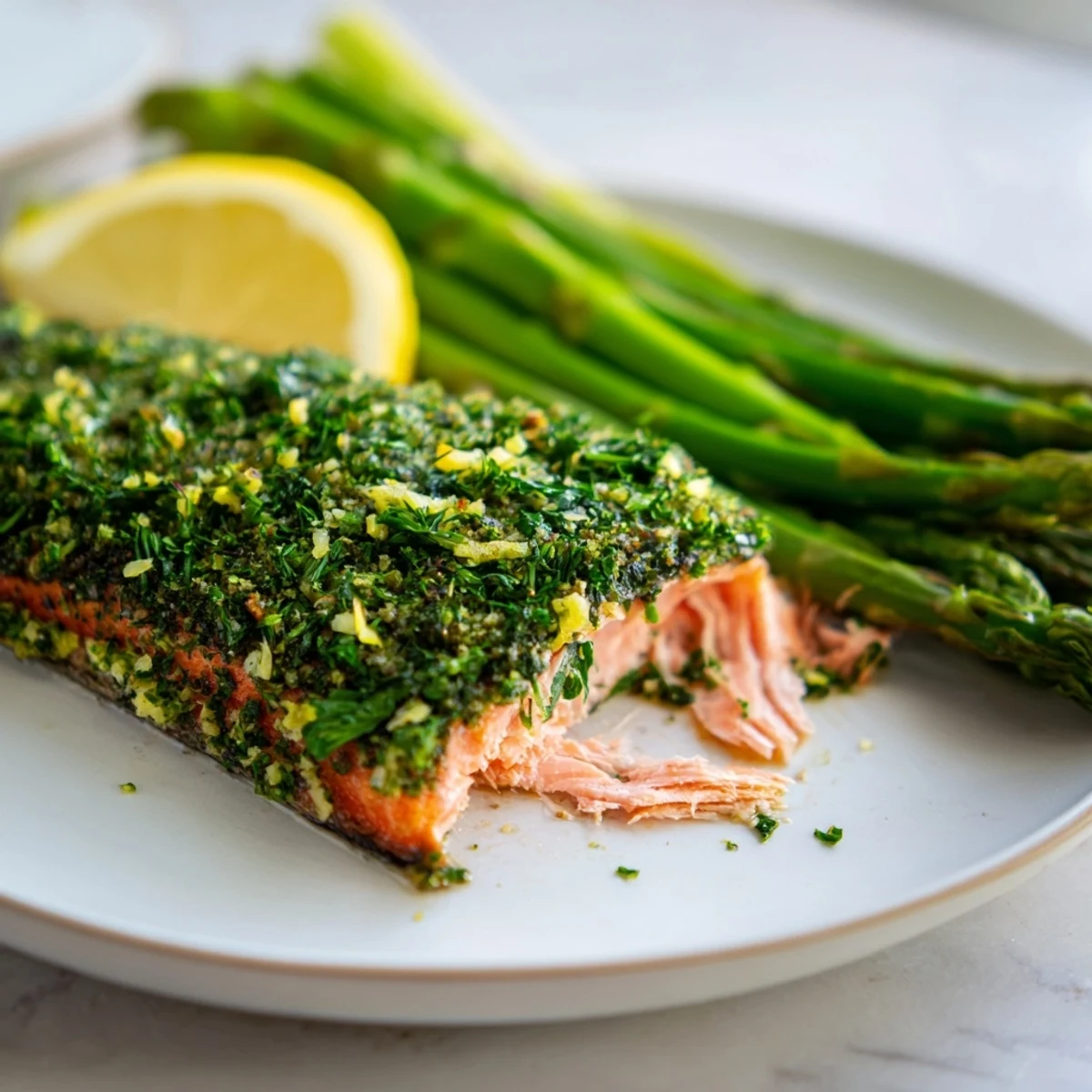 Golden-brown herb-crusted salmon fillets bake alongside tender green asparagus spears on a parchment-lined sheet pan, ready for a quick weeknight dinner.