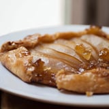 A whole Rustic Pear and Ginger Galette with a beautifully browned crust, ready to be sliced and served warm with a scoop of vanilla ice cream.
