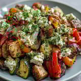A close-up of vibrant Roasted Mediterranean Greek Vegetables with feta, parsley, and Kalamata olives.