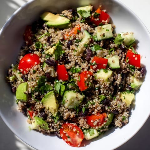 Zesty quinoa and black bean salad with avocado and cherry tomatoes, perfect for a healthy lunch.