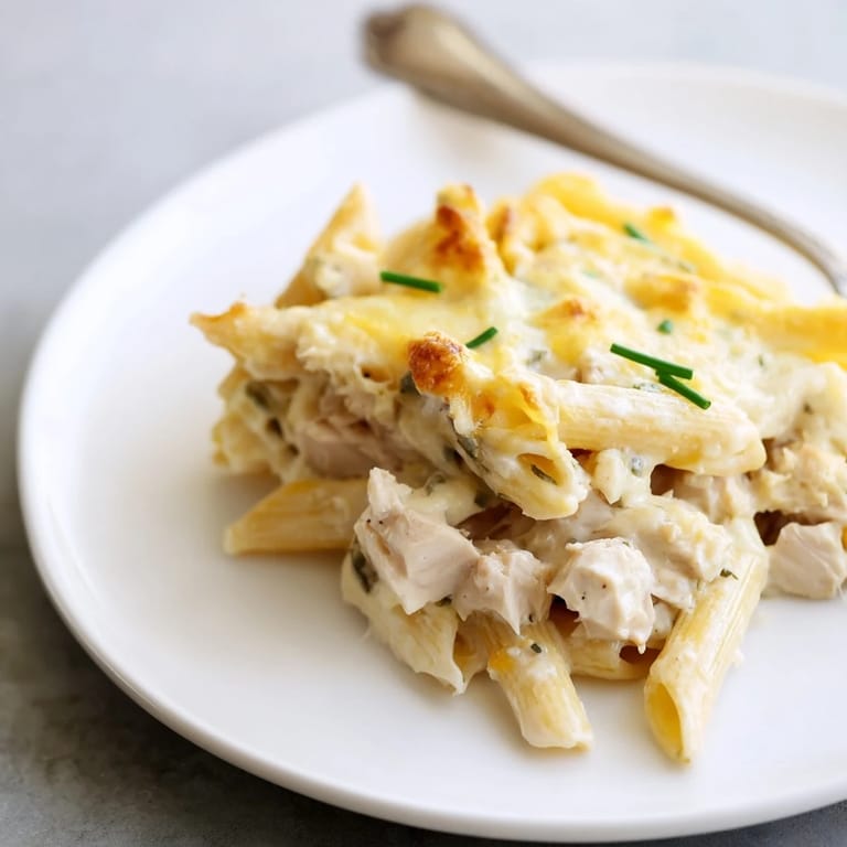 A close-up of creamy Chicken Ranch Pasta Bake with tender chicken, penne pasta, and bubbly cheese, ready to serve.  