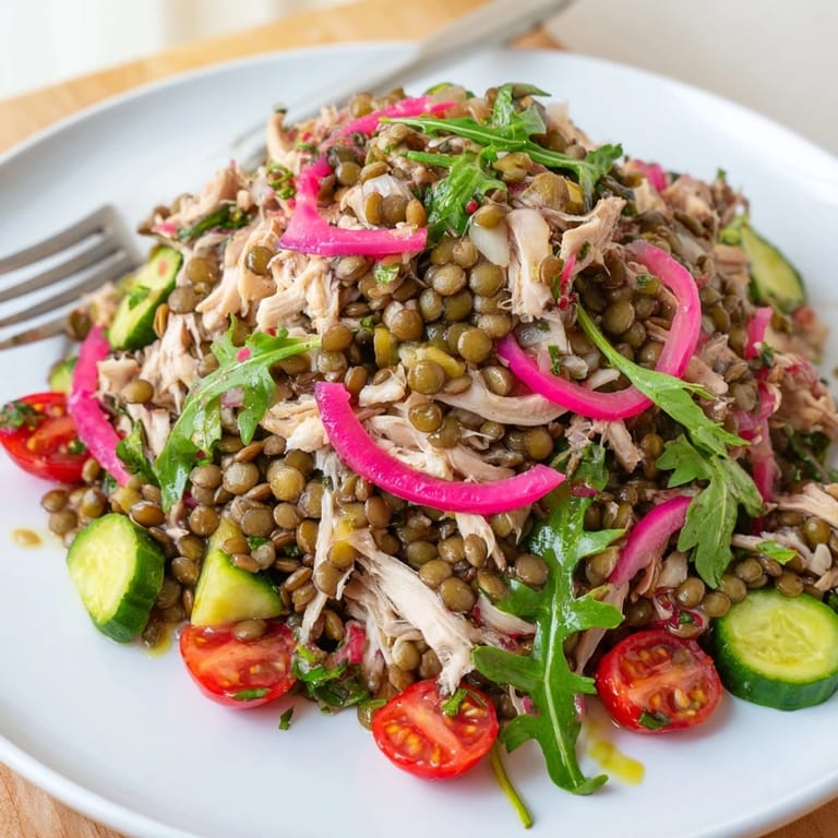 Dinner plate showcasing the Lentil & Chicken Spring Salad featuring roasted chicken, crisp greens, and a glistening mustard vinaigrette.